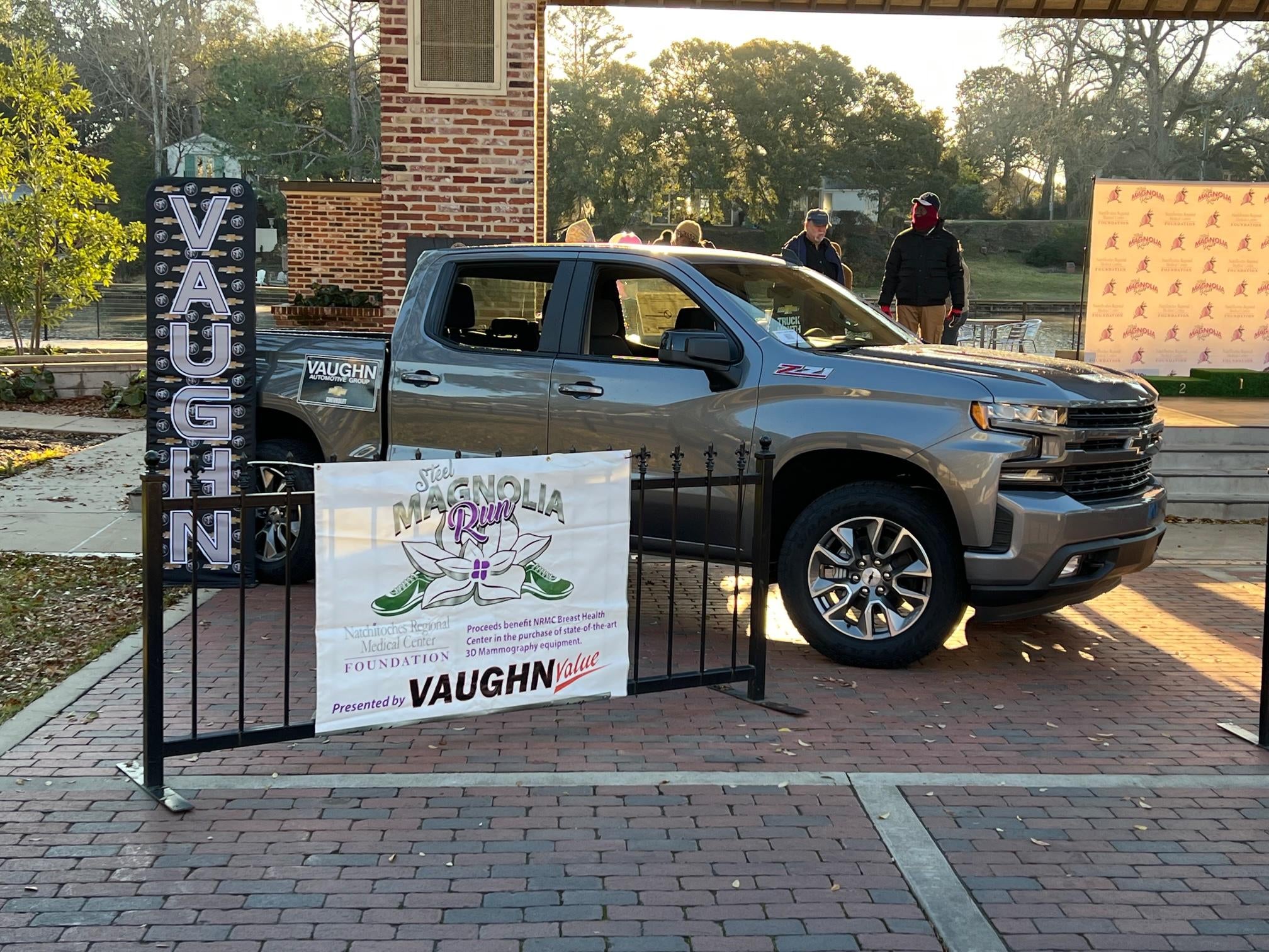 image of side of Chevorlet truck next to a sign that has Vaughn spelled veritcally and another sign for the Steel Magnolia Run