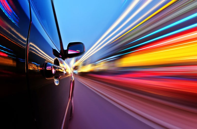 image of side of car driving with long exposure causing a colorful blur effect on the side